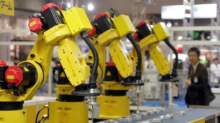 Industrial robot arms operating on an automated assembly line in a factory